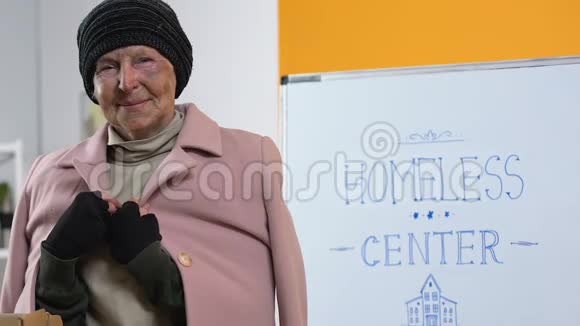可怜的无家可归的妇女穿着捐赠的温暖衣服在支持中心寻找相机视频的预览图