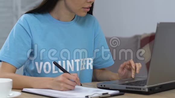 微笑志愿者比较笔记本电脑和书面清单上的数据寻找相机视频的预览图