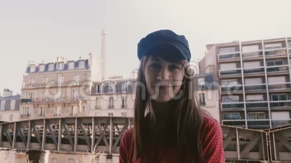 美丽的年轻快乐的旅游妇女微笑着指着阳光明媚的埃菲尔铁塔观景巴黎公寓阳台慢动作视频的预览图