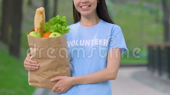 志愿者带着食物包在户外微笑为饥饿的人们捐款视频的预览图