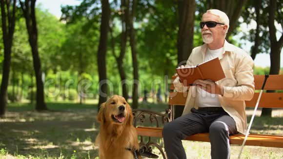 有狗的盲人在公园里享受休息为残疾人提供社会保护视频的预览图