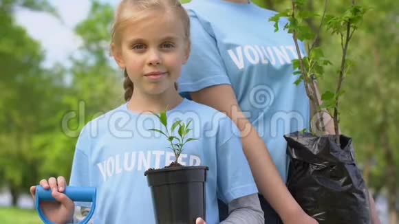 女孩和母亲拿着植物树苗和铲子环境志愿服务视频的预览图