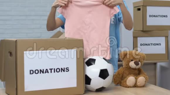 女士自愿把孩子们的东西放进盒子里微笑着对坎姆帮助孤儿院视频的预览图