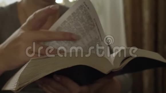 女人读一本书翻页圣经合上视频的预览图