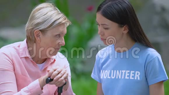 女志愿者用拐杖和老妇人交谈心理支持户外视频的预览图