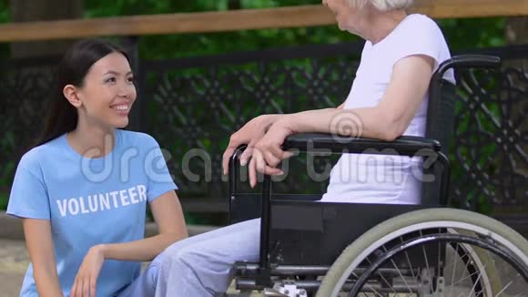 一位坐轮椅的残疾老太太在养老院公园的志愿者视频的预览图