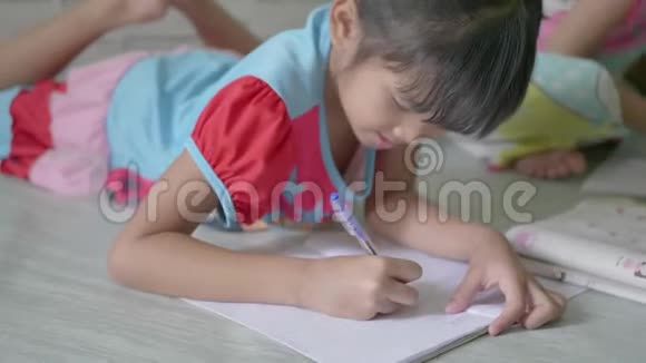 孩子们小女孩在家学习功课并在笔记本上写下视频的预览图