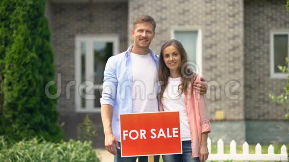 一对幸福的夫妇站在附近卖招牌一家人搬到另一个地方视频的预览图