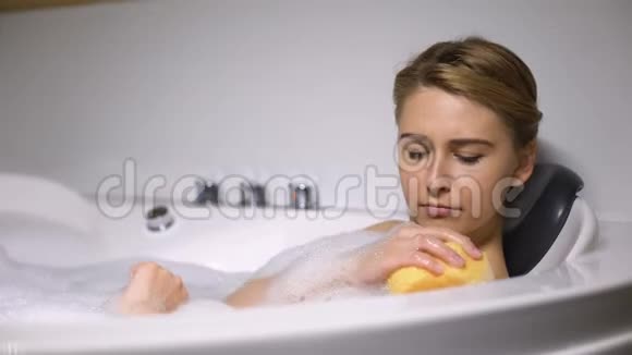 女孩躺在浴缸里用海绵洗身体日常美容程序清新视频的预览图
