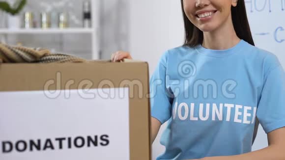微笑的志愿者站在捐赠衣物无家可归者援助的箱子旁边视频的预览图
