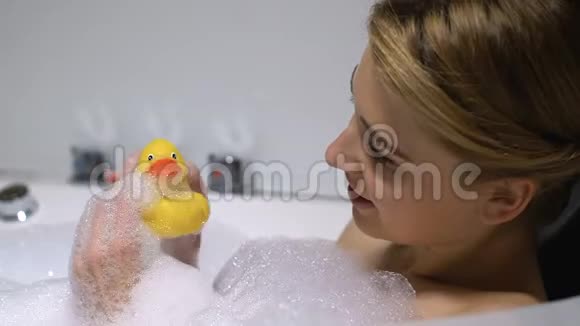 快乐的年轻女人在洗澡和大笑中玩橡皮鸭心情好视频的预览图