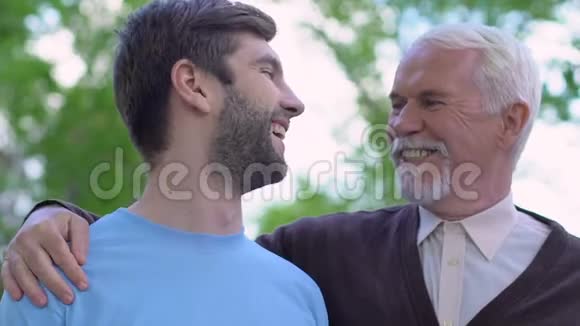 快乐的祖父拥抱微笑的儿子信任的家庭关系志愿者视频的预览图
