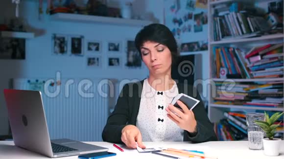 一个女孩坐在办公桌前检查一张偏振片的照片视频的预览图