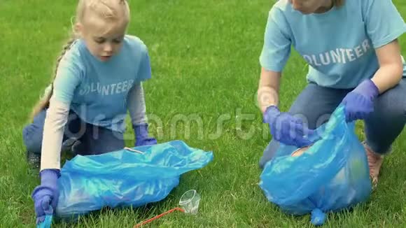 妈妈和小女孩志愿者在公园里收集垃圾给他们击掌视频的预览图