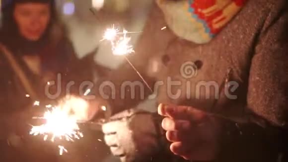 一群朋友在他们手中点燃火花圣诞前夜新年假期或生日聚会快乐的人视频的预览图