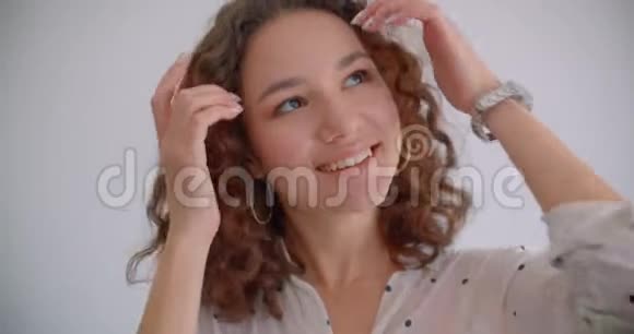 年轻的长着头发的卷曲的白种人女性的特写照片她把手指放在嘴唇上开心地微笑着摆姿势视频的预览图