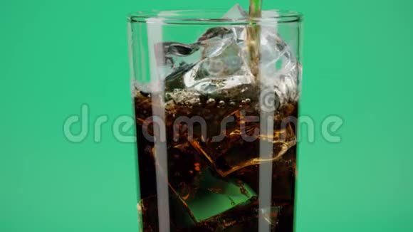将可乐软饮料倒入杯中在绿色背景下加入冰块在红色动作拍摄红色视频的预览图