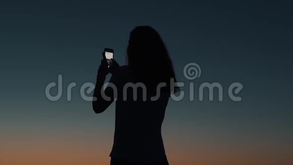 女孩在日落时拍照视频的预览图