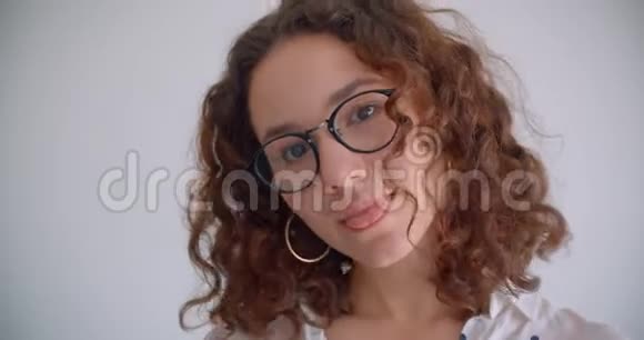 年轻的长着头发的白种人戴着眼镜带着诱人笑容看着镜头的女性特写视频的预览图