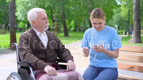 幸福年轻女子送耳机老人支持医院病人视频的预览图