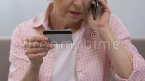 老年女性持有信用卡拨打银行热线金融咨询视频的预览图