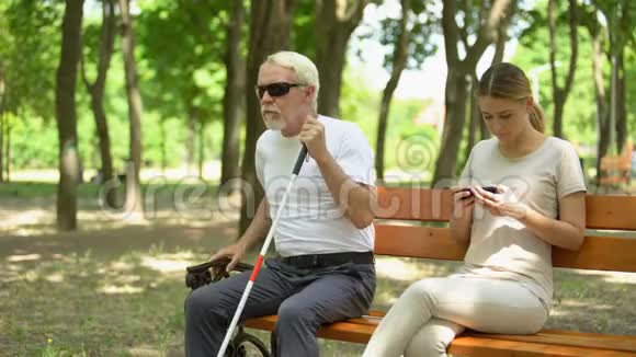 善良的女儿帮助失明的老父亲在公园散步关心关系同情视频的预览图