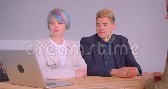 商务合作伙伴的特写镜头男女在午餐会上使用坐在桌子旁的笔记本电脑视频的预览图
