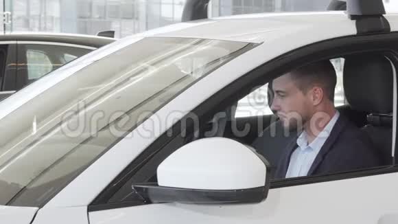 快乐的帅哥在里面检查一辆新车的内饰视频的预览图