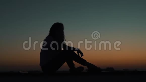 日落时分坐在屋顶上的女孩视频的预览图