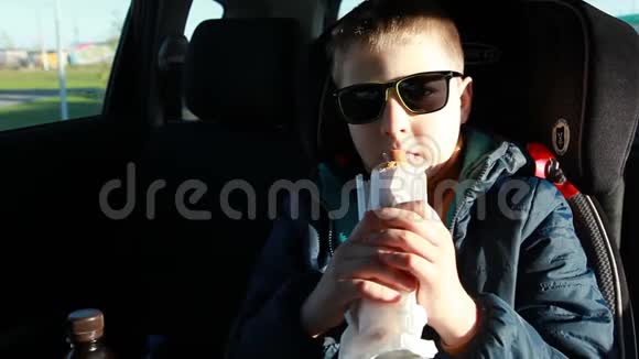 一个男孩在车里吃热狗视频的预览图