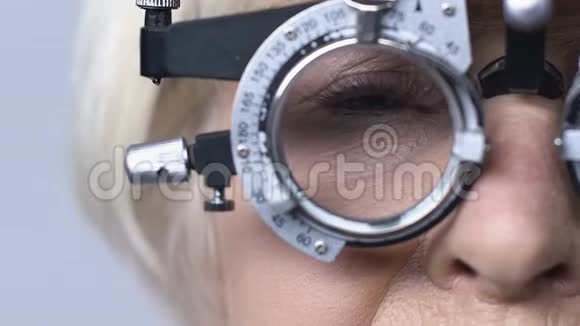 老年妇女在光学实验架上坐着眼科医生柜视力检查视频的预览图