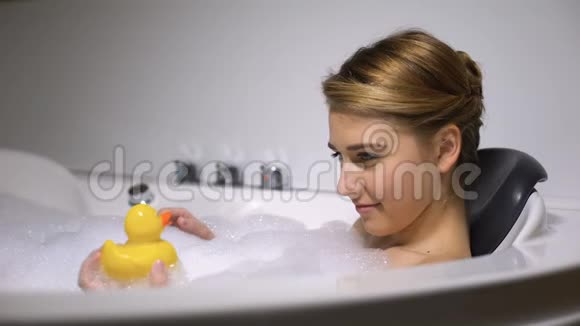 有趣的女人在泡泡浴时对橡皮鸭大喊大叫孩子气视频的预览图