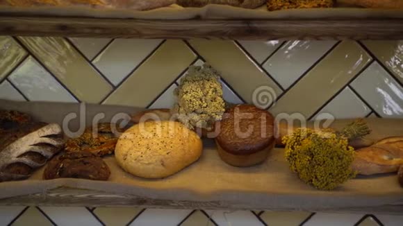 在面包店的货架上摆满了各种面包和烘焙食品其中有新鲜的烤脆面包有机谷物生物视频的预览图