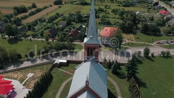 在白俄罗斯风景如画的乡村中德龙在哥特式教堂周围飞翔视频的预览图