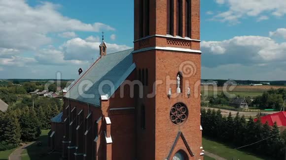 在白俄罗斯风景如画的乡村中德龙在哥特式教堂周围飞翔视频的预览图