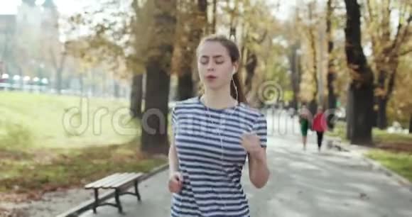 年轻女子跑步训练在夏季公园关闭健身妇女慢跑户外疲倦的女孩慢跑后呼吸视频的预览图
