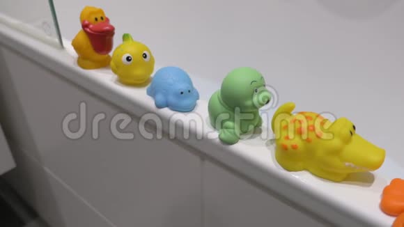 浴缸边上的一排橡胶小玩具视频的预览图