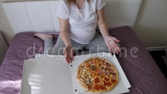 穿着白色t恤坐在床上的怀孕女孩视频的预览图