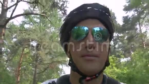 戴绿色飞行镜太阳镜的人骑自行车视频的预览图