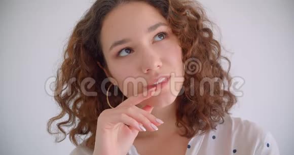 一位年轻的长头发的白种人卷曲的女性体贴地笑着开心地看着摄像机视频的预览图