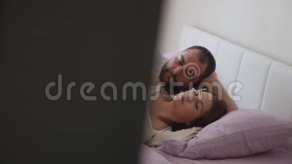 孕妇和一个穿白色T恤衫的男人躺着视频的预览图