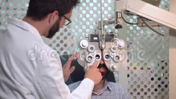 眼科医生用视觉检查装置检查病人男性眼科检查视力的病人视频的预览图