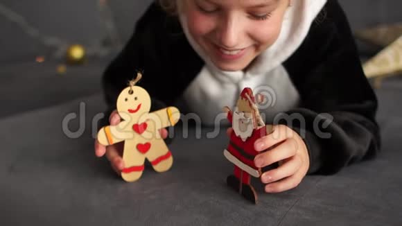 这个女孩有兴趣玩木头人物来装饰圣诞树圣诞前夜等待礼物视频的预览图