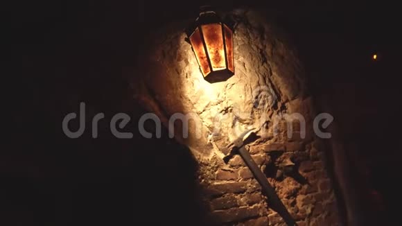 一盏旧灯笼挂在砖墙上照亮了一个矿工的采矿采摘背景视频的预览图