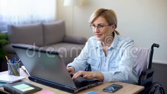 一位坐轮椅手提电脑与客户聊天的成功女性视频的预览图