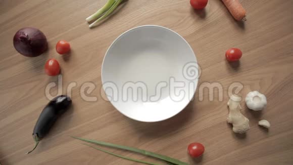 然后起飞然后把普通的白色盘子放在一张带蔬菜的木桌上视频的预览图