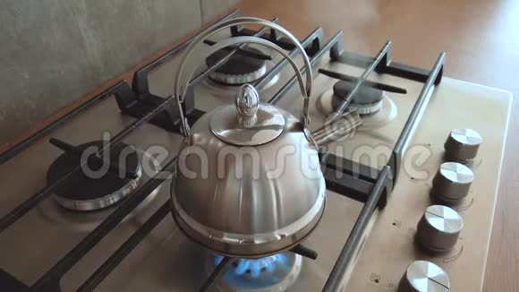 在家用煤气炉上烧开钢金属水壶家庭用开水煮茶室内蒸汽视频的预览图