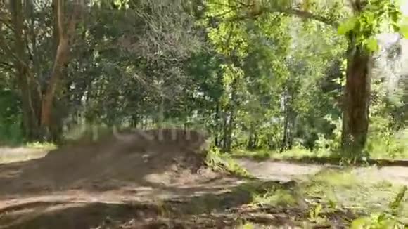 骑自行车在森林里的跳板上跳山地自行车骑自行车者下山视频的预览图