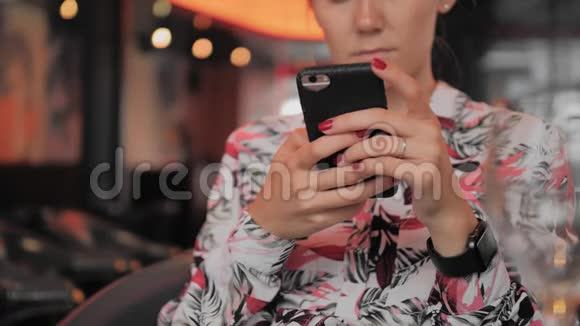 未被识别的年轻女性法国女性在坐在餐馆时使用智能手机手上拿着一只智能手表视频的预览图