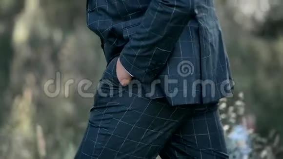 一个穿着时髦西装的男人手插在口袋里走路视频的预览图